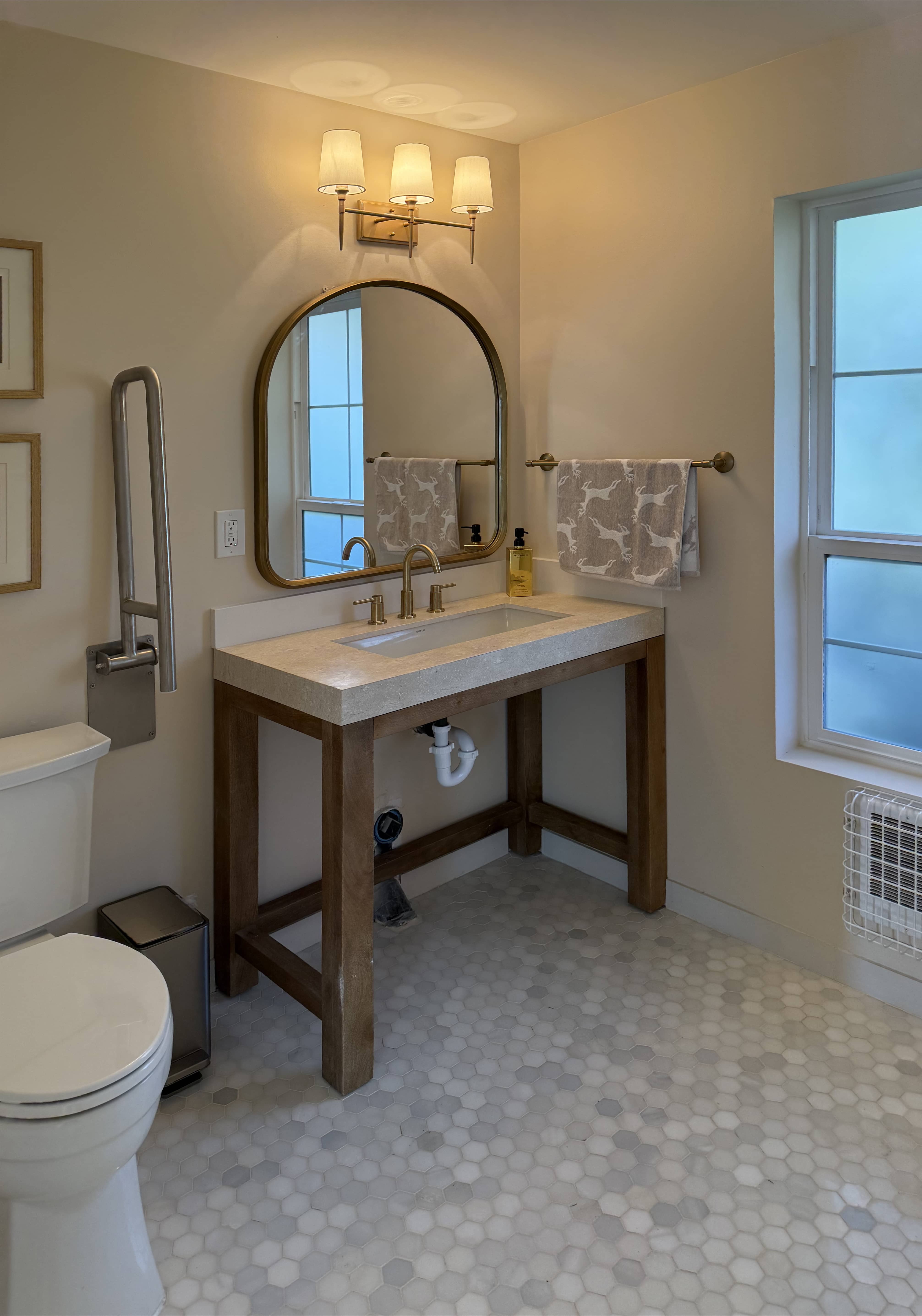 Walk-in shower with tile, glass enclosure, and integrated grab bars.