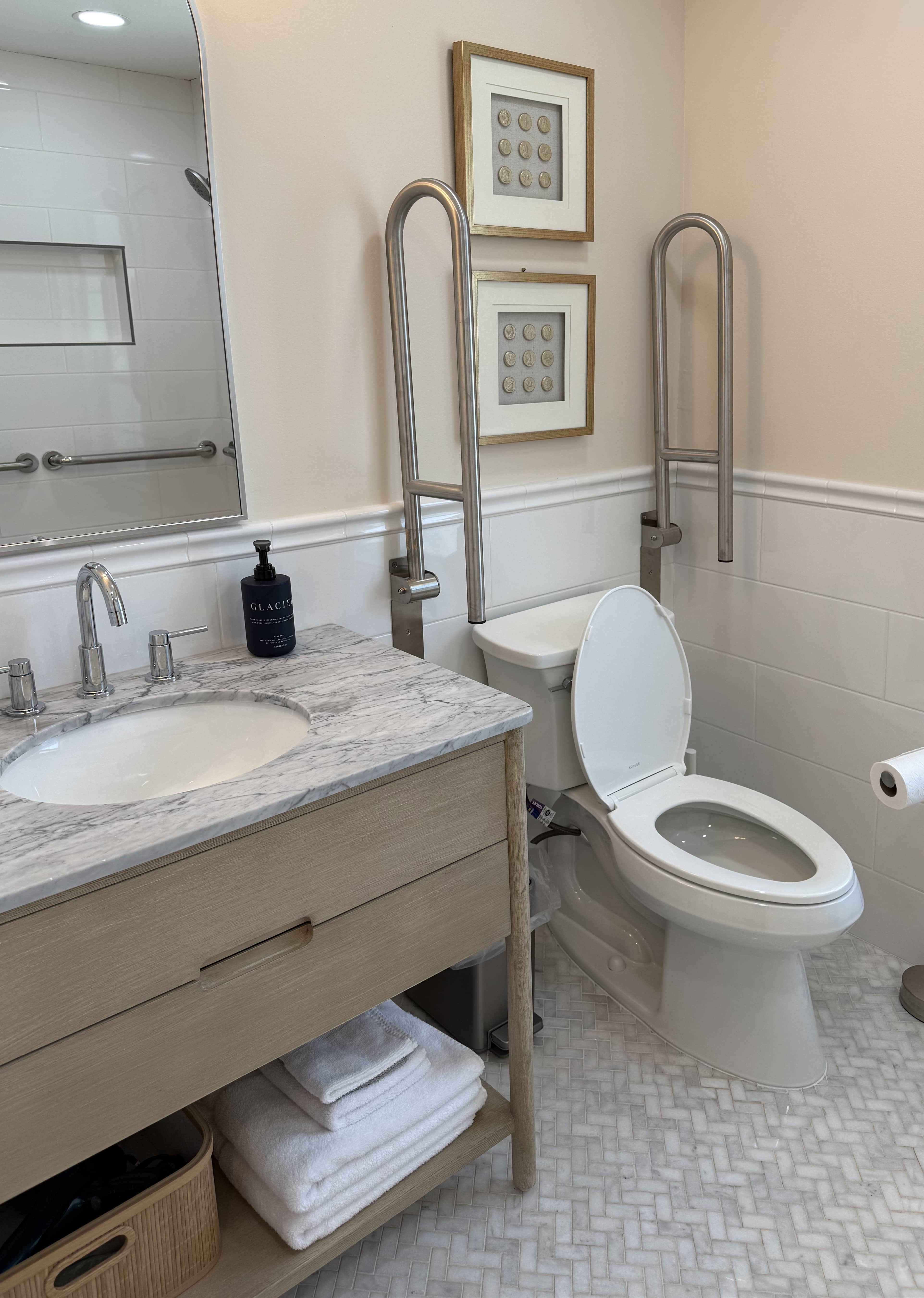 Bathroom vanity with neutral counters and a wide framed mirror.