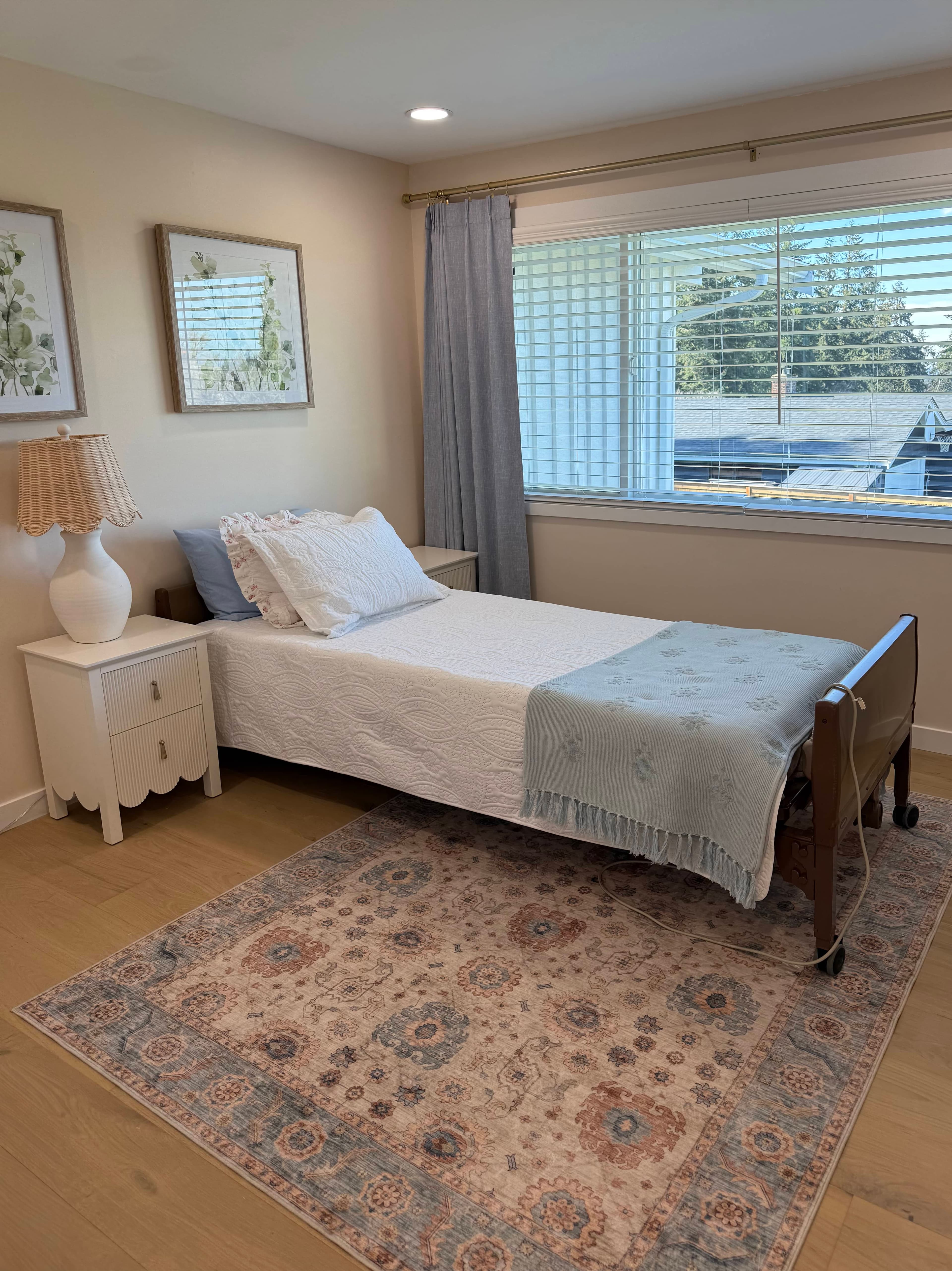 Bedroom with neutral linens, a nightstand, and a window-side reading chair.