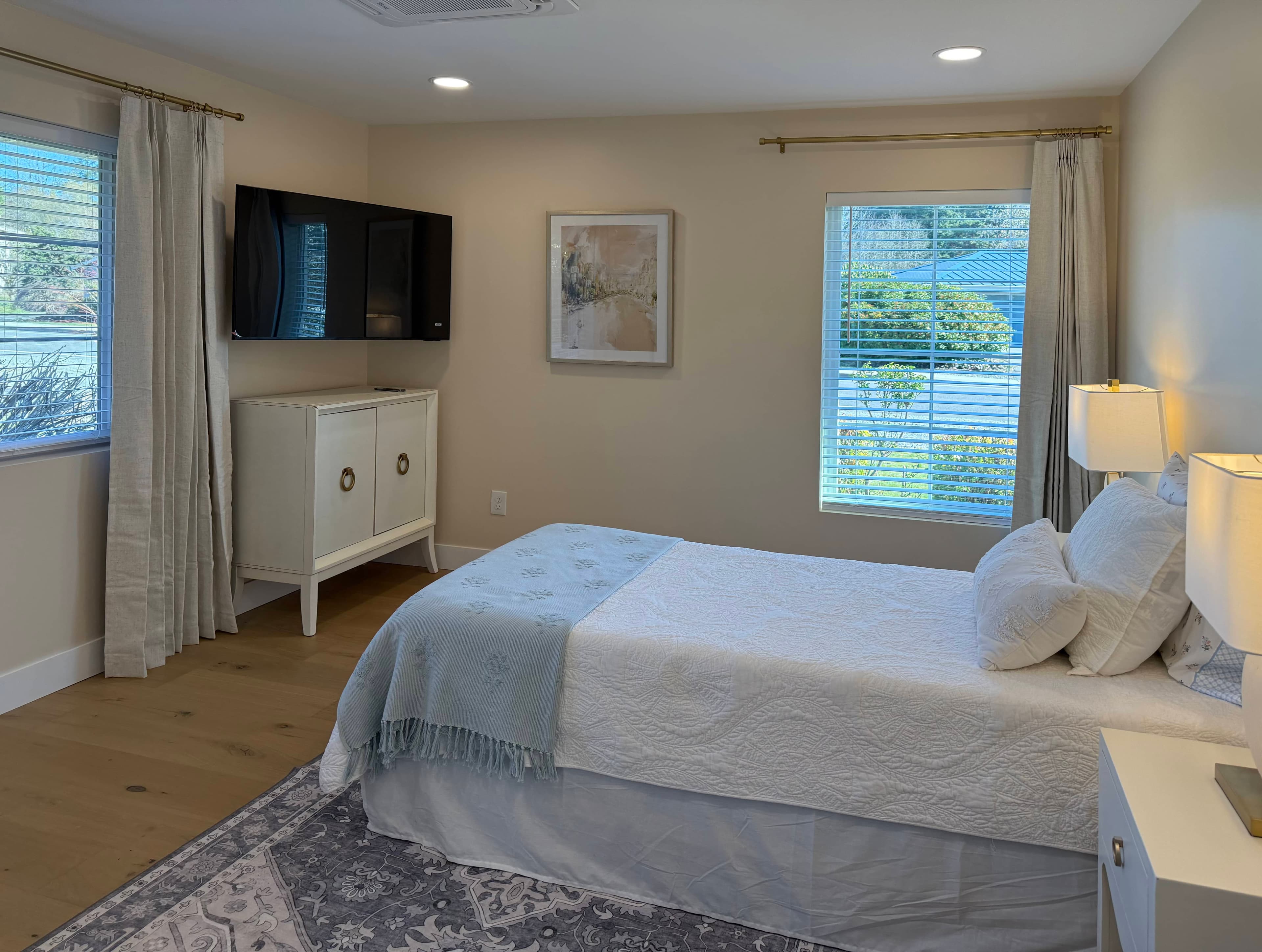 Bedroom with double exposures of natural light and minimal furniture.