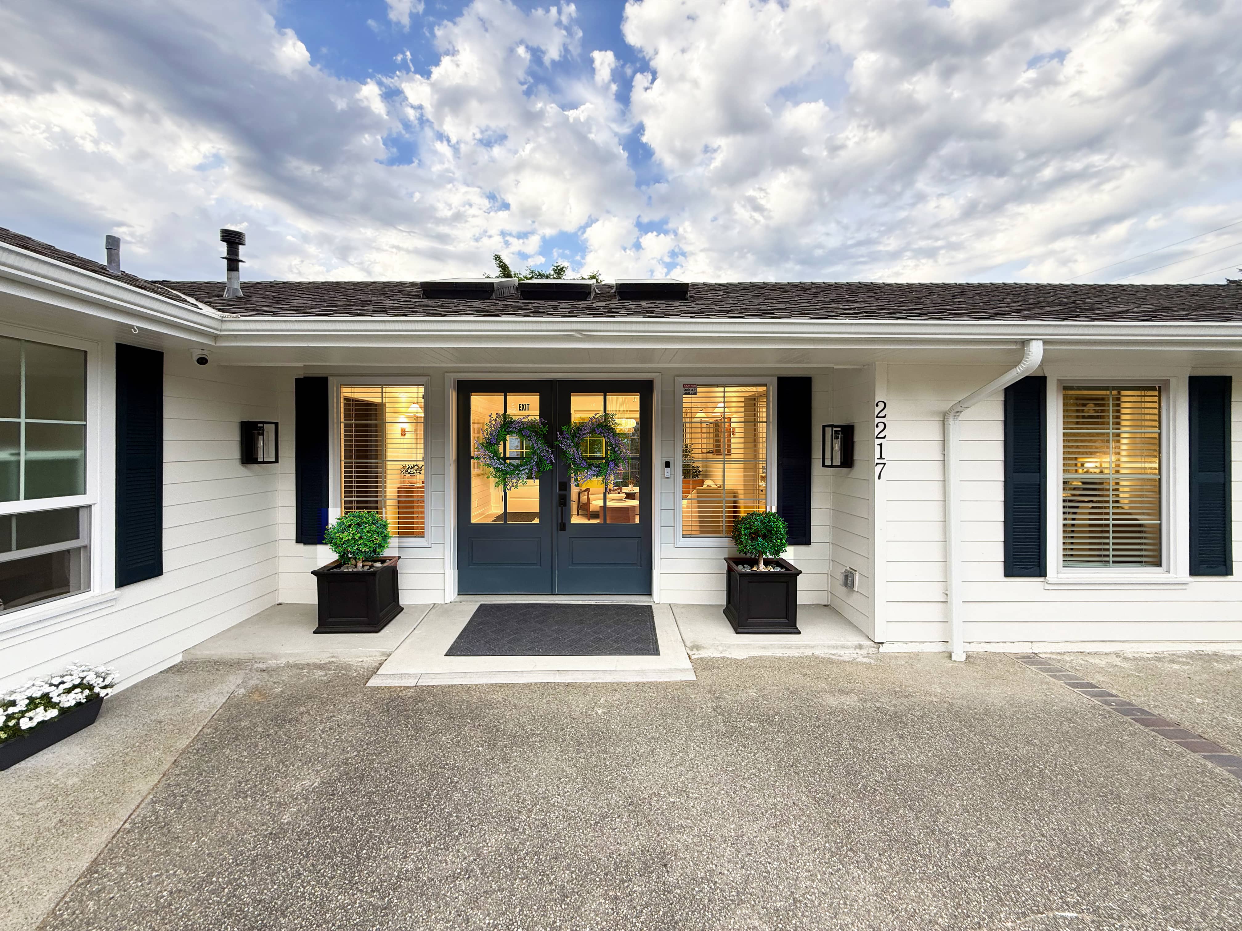 The front of Norwood House in Bellevue, a residential home framed by trees in afternoon light.