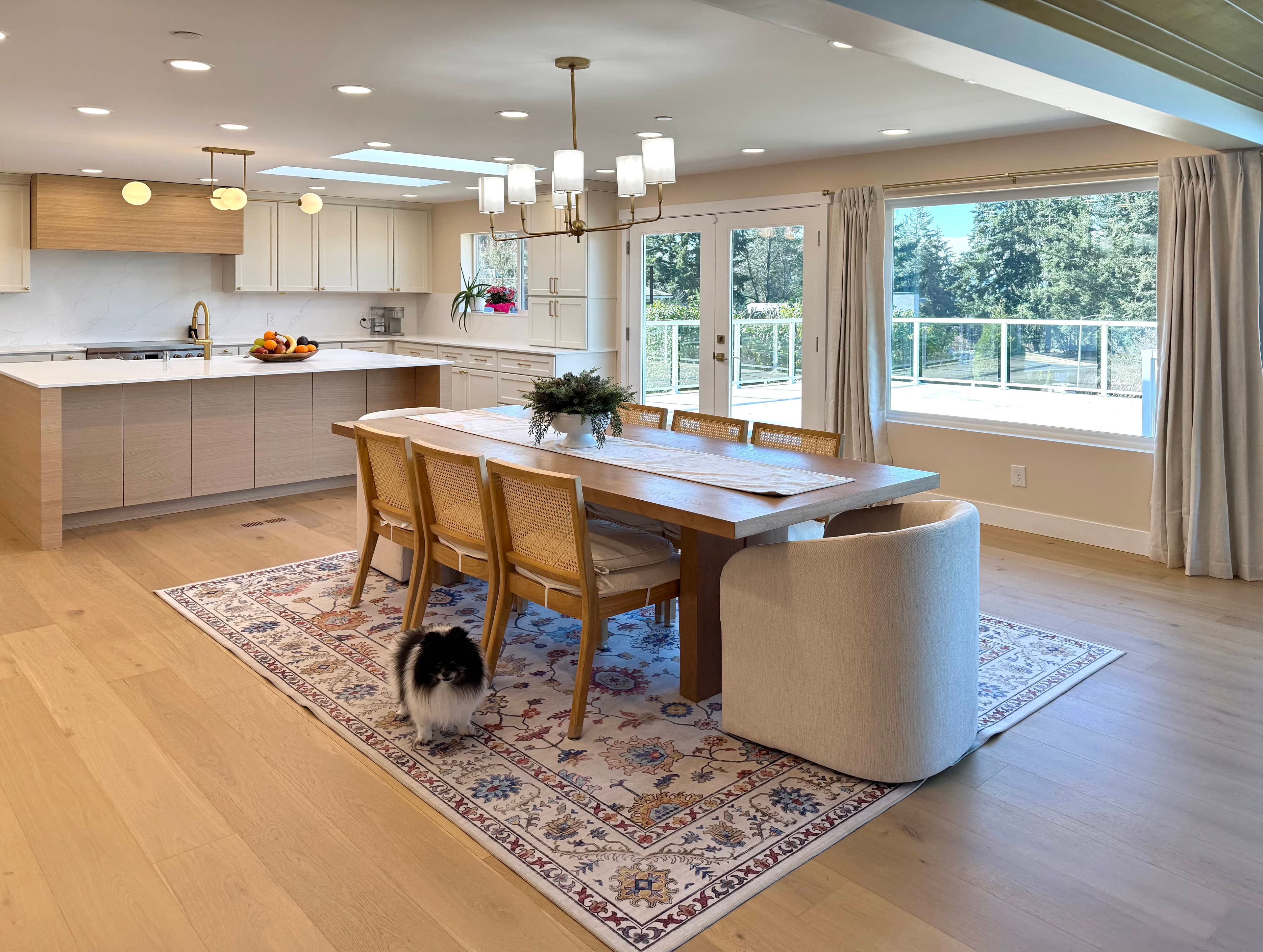 The dining area at Norwood House: a wood table set near the kitchen, with warm light from large windows.